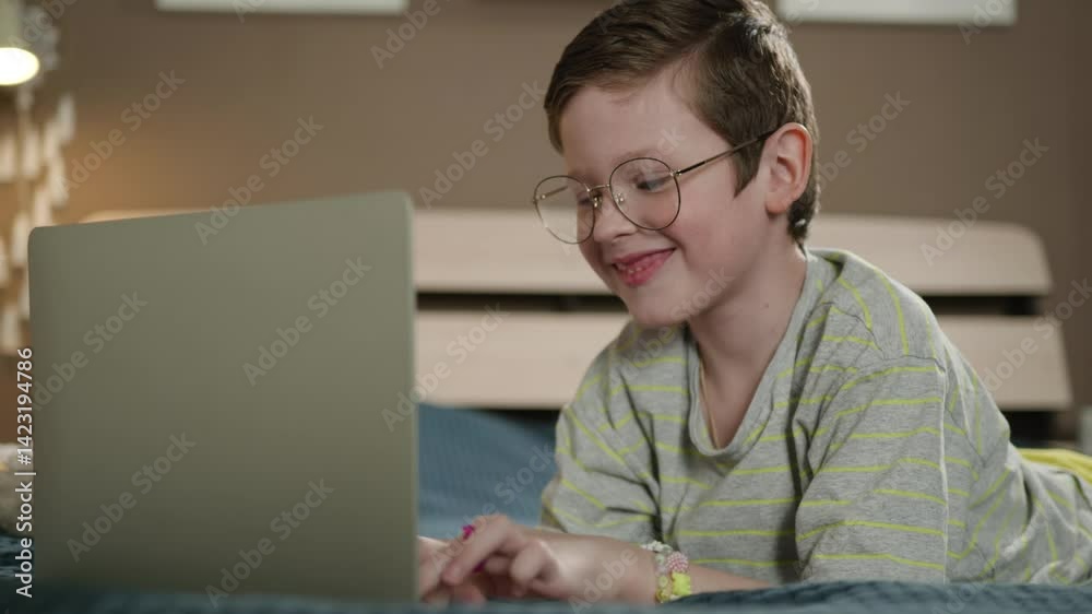 Child laptop typing. Cheerful boy in daddy glasses typing on laptop