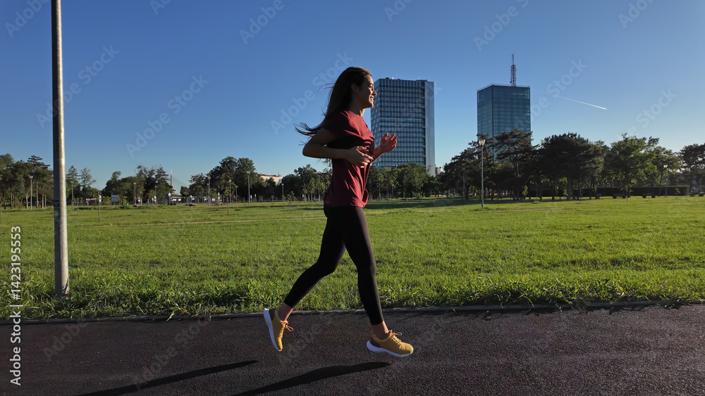 Young woman running and jogging in urban park.