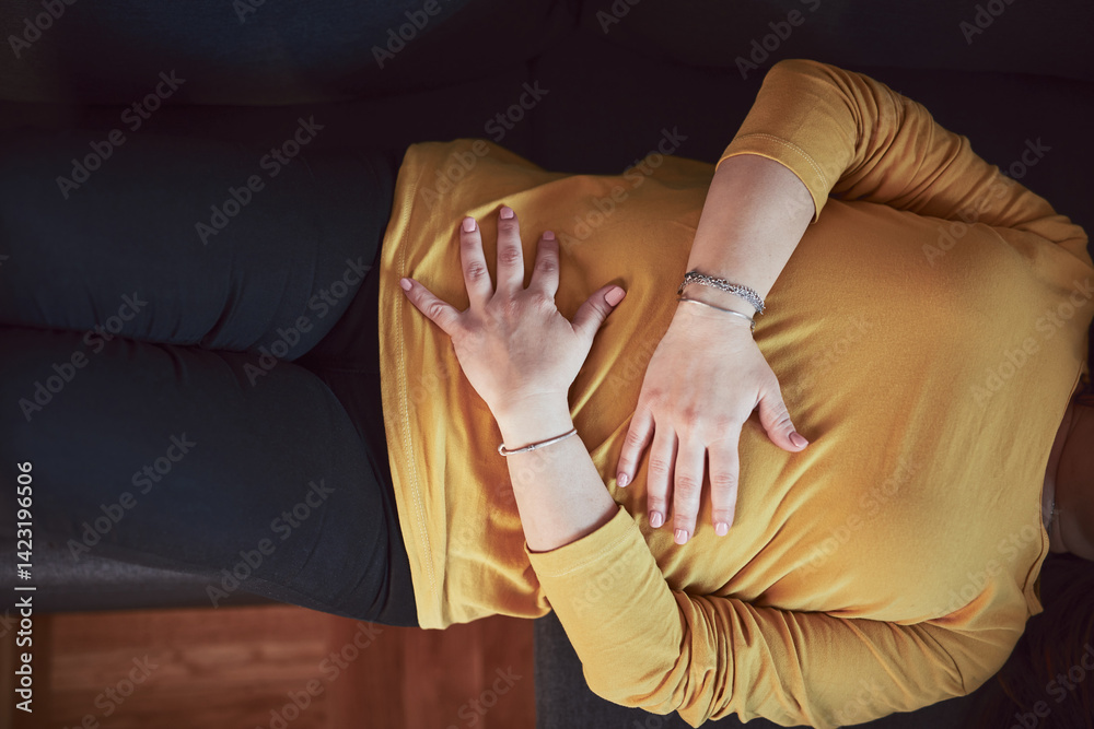 Woman with strong stomach ache, menstrual and digestive issues at home.