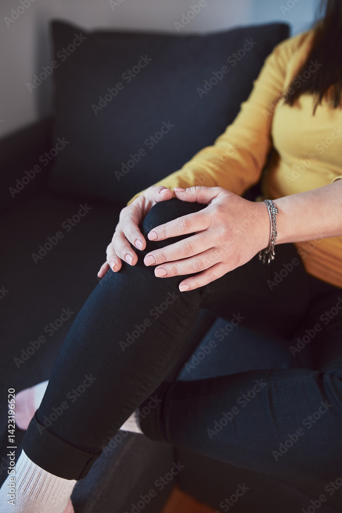 Woman with painful knee and leg injury at home.