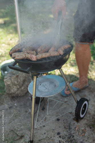 Obraz na płótnie Man preparing barbeque in the garden on a hot summer day. w salonie