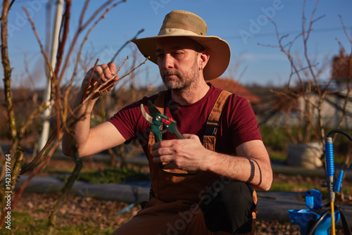 Obraz na płótnie Male gardener with pruning shears working in a blueberries organic farm. w salonie
