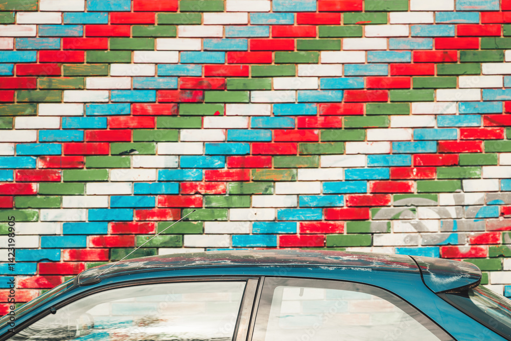 Fototapeta premium Car roof next to the brick wall with Azerbaijan flag pattern painted bricks