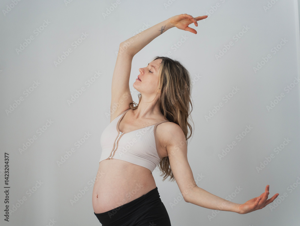 Young attractive pregnant woman dancing, grace conscious movement choreography concept