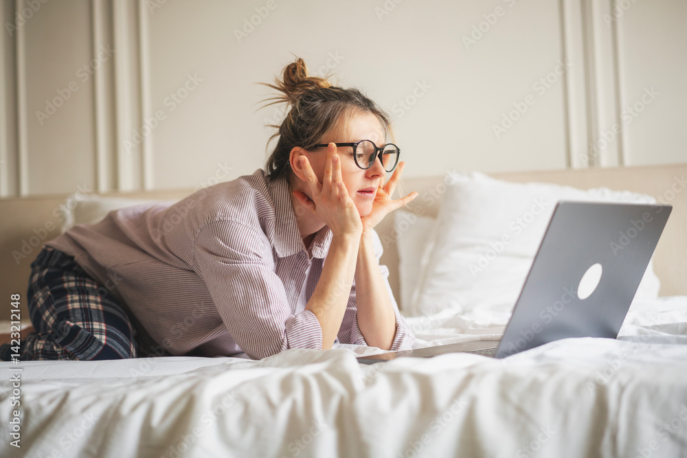 Beautiful smiling woman using laptop in bed
