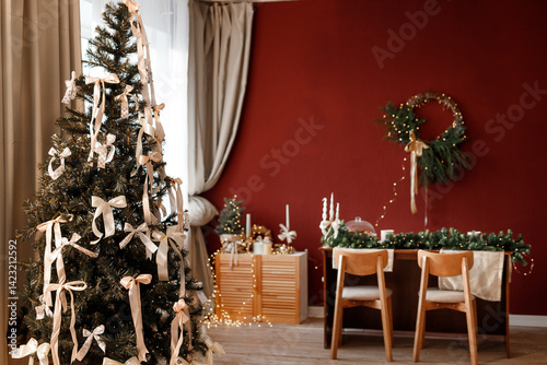 Beautifully decorated New Year's room. A festive table with candles, a decorated Christmas tree