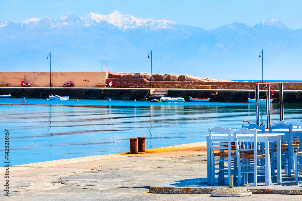 Sea, cafe tables and snow mountains in Peloponnese, Greece