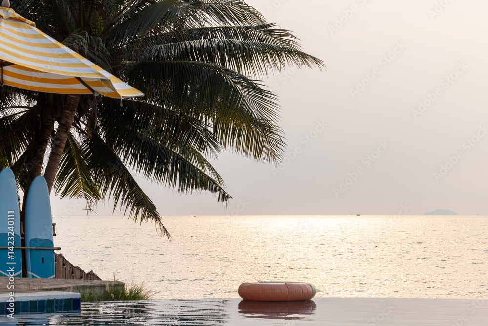Inflatable circle floats on the pool at sunset, Surround tropical decor and greenery palm tree, Relaxing summer holiday, Inflatable ring float on water sunset view, Summer background vacation leisure.