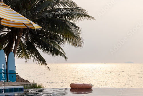 Obraz na płótnie Inflatable circle floats on the pool at sunset, Surround tropical decor and greenery palm tree, Relaxing summer holiday, Inflatable ring float on water sunset view, Summer background vacation leisure. w salonie