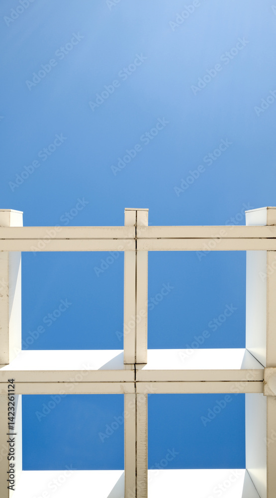 Striking modern architecture with geometric white pergola structure against deep blue sky. Symmetrical grid pattern and minimalist design Striking modern architecture with geometric white pergola structure against deep blue sky. Symmetrical grid pattern and minimalist design