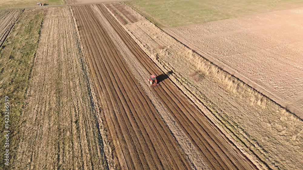 Drone shot of tractor on plowed soil