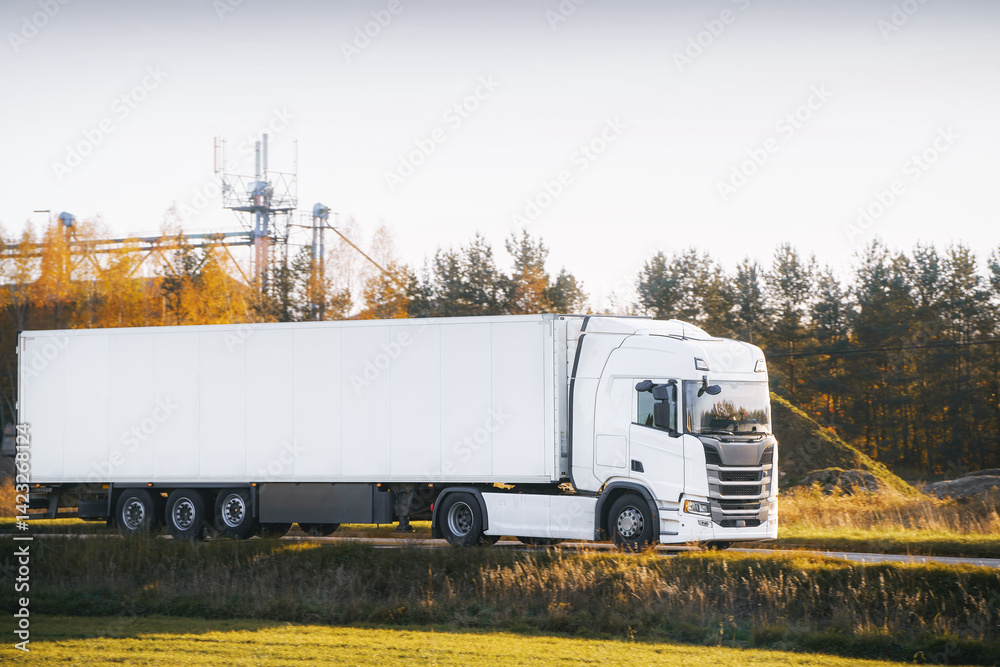White trailer truck driving forest highway