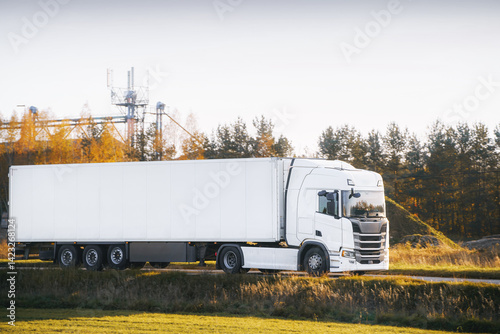 White trailer truck driving forest highway