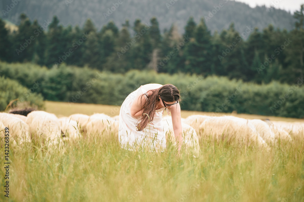 Smiling woman and sheep in grassy field