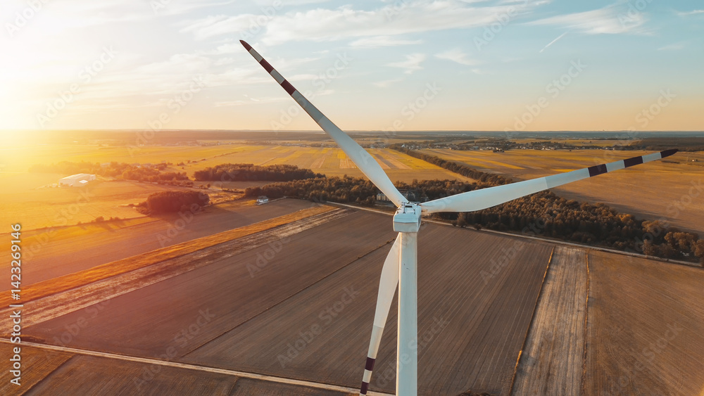 Sunset over green farmland wind turbine
