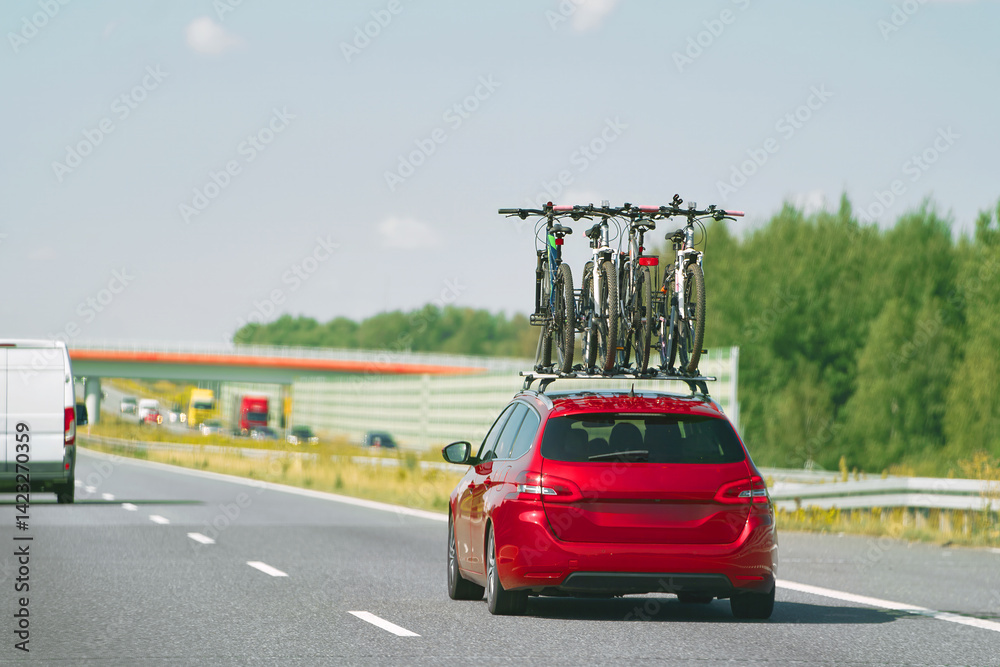 Car with roof-mounted bikes driving on road