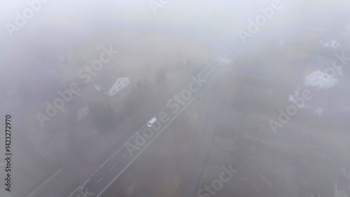Aerial shot highway disappearing into thick mist