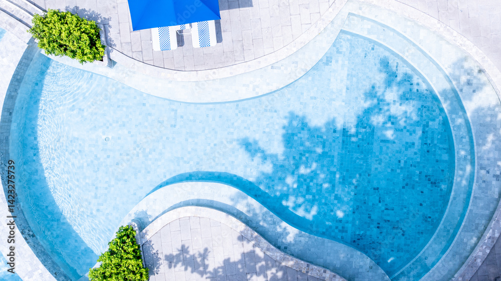 Top view swimming pool blue water in summer with umbrella pool and deck beach chair, Empty swimming pool with sunbed and umbrella pool in resort hotel for vacation leisure, Summer vacation holiday.
