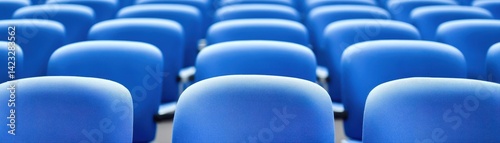 Close-up view of blue theater seats arranged in a row with a focus on the vibrant and uniform seating in an indoor torium or cinema environment