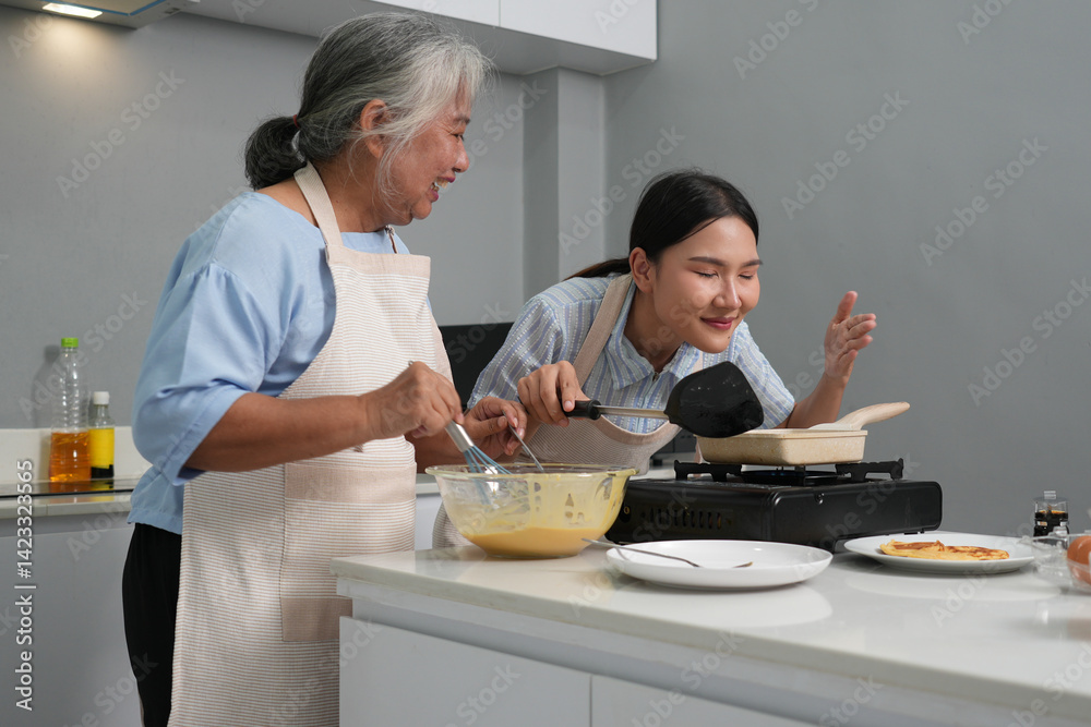 Two women, daughter cooking with elderly mother at home, happy mother's day, family day