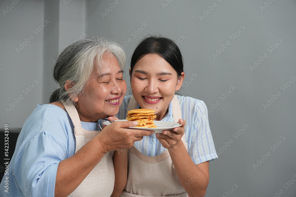 Two women, daughter cooking with elderly mother at home, happy mother's day, family day