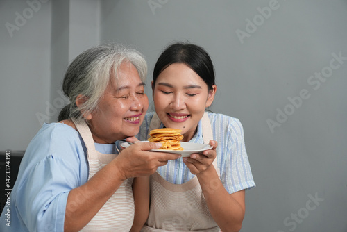 Obraz na płótnie Two women, daughter cooking with elderly mother at home, happy mother's day, family day w salonie