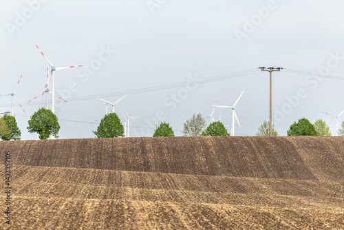 Obraz na płótnie Ein Feld Acker mit Windenergieanlegen dahinter w salonie