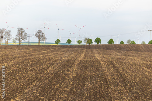 Obraz na płótnie Ein Feld Acker mit Windenergieanlegen dahinter w salonie