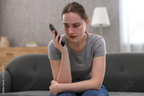 Obraz na płótnie Depressed woman calling hotline for mental health help on sofa at home w salonie