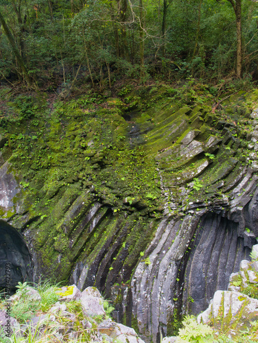 Detailed view of columnar basalt rock wall in Takachiho Gorge, formed by cooled lava flows. Geologic textures reflect Kyushu's volcanic history and erosion by the Gokase River.