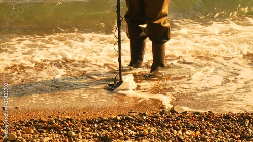 Metal Detecting Beach treasure waves search during day by shore rocks