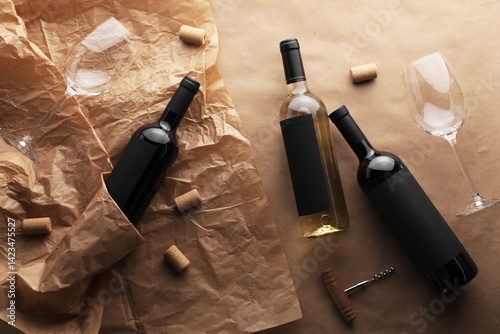 Obraz na płótnie Bottles of wine, glasses, corkscrew and corks on parchment paper, flat lay w salonie