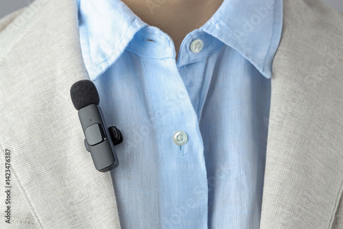 Man with lavalier microphone attached to his suit, closeup