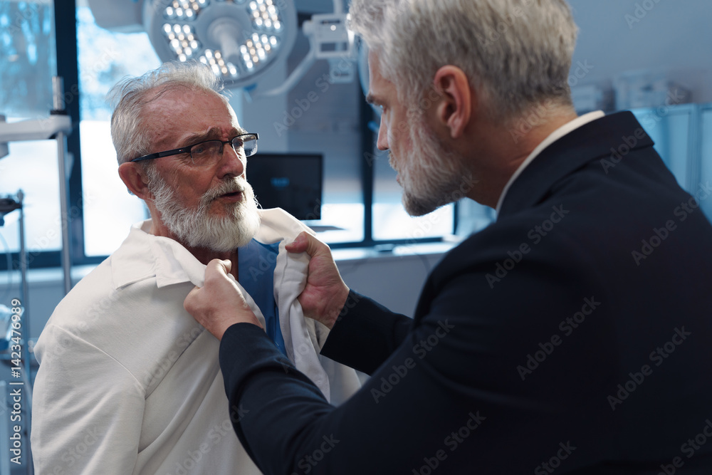 Aggressive man have conflict with doctor, holding him by coat. Aggressive man have conflict with doctor, holding him by coat.