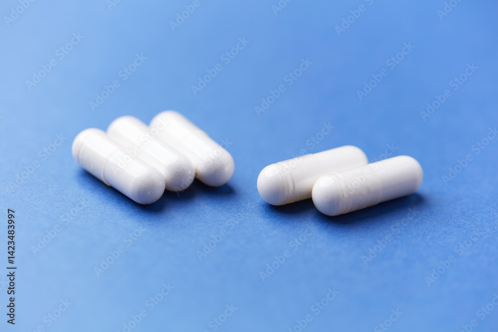 Arginine capsules on bright background. Soft focus. Close up. Copy space. Arginine capsules on bright background. Soft focus. Close up. Copy space.