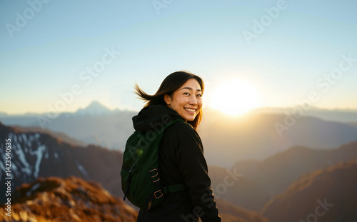 Middle-aged woman hiking during sunrise or sunset with joyful smile