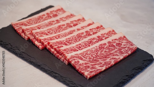 Obraz na płótnie Freshly sliced red meat on a black slate plate. w salonie