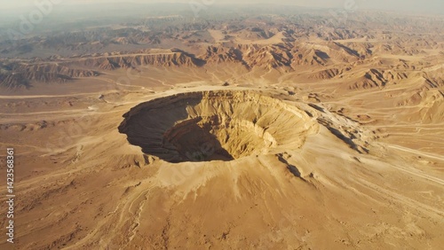 Obraz na płótnie A large hole in the ground with a lot of dirt around it. The hole is in the middle of a desert w salonie