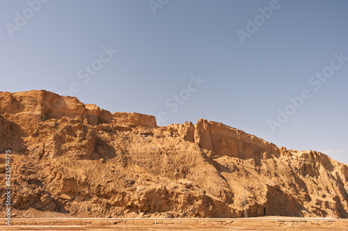 A rocky hillside with a clear blue sky in the background