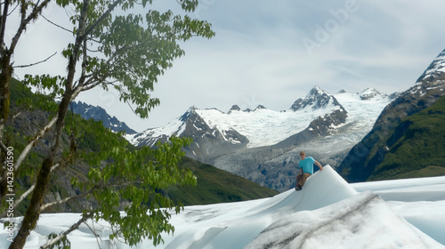 Adventurer climbing on glacial ice with stunning mountain backdrop