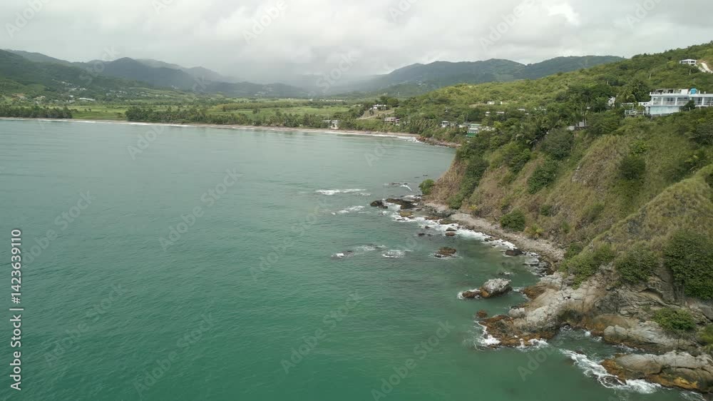Aerial drone video of the ocean with a steep rocky coastline and cloudy weather. Mountains in the background. Aerial drone video of the ocean with a steep rocky coastline and cloudy weather. Mountains in the background.