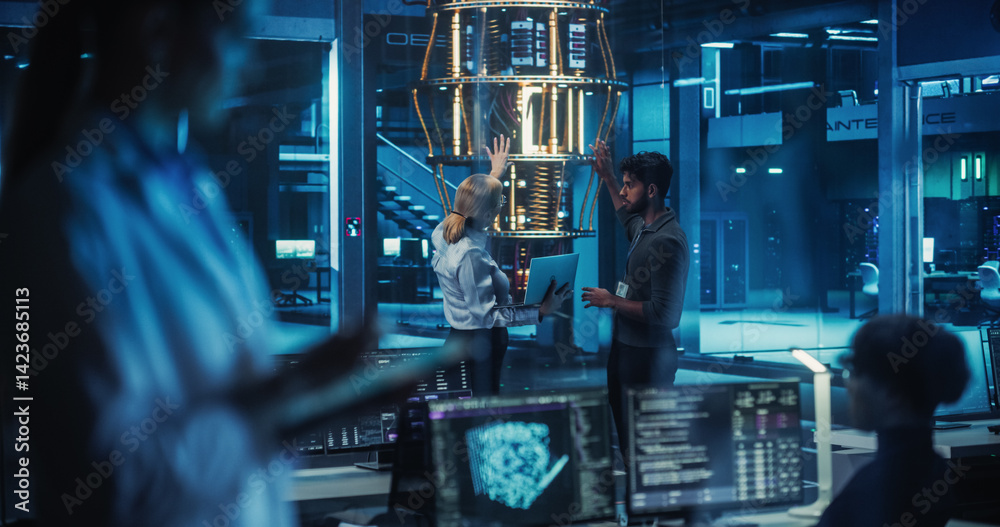 Naklejka premium In a Futuristic Science Lab, Diverse Engineers Discussing a Quantum Computer Project, Analyzing Data on a Laptop. Team of Female and Male Specialists Working to Improve and Scale a Quantum Processor