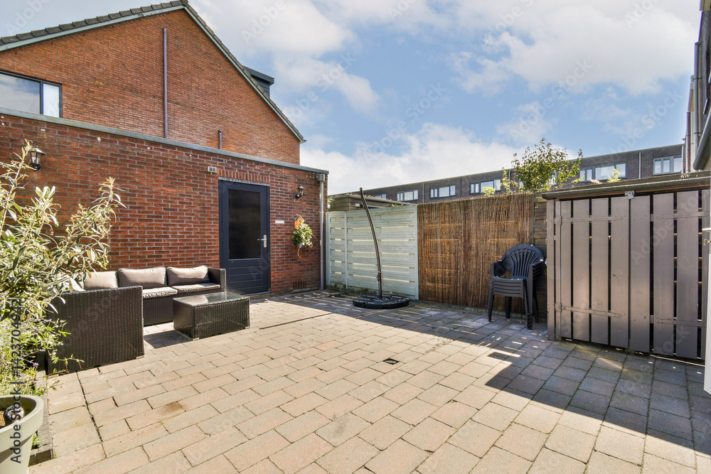 Obraz premium A stylish patio area showcasing contemporary furniture, surrounded by greenery and sleek fencing, perfect for relaxation and outdoor gatherings.