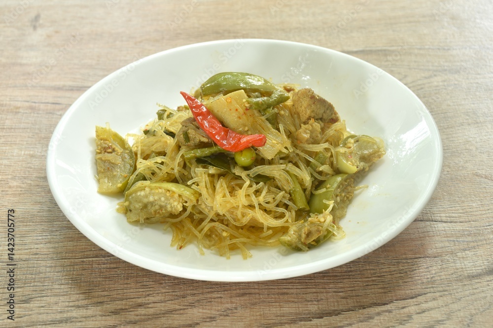 stir fried spicy mixed glass noodles with vegetables and pork belly in Curry powder Thai northern style on plate stir fried spicy mixed glass noodles with vegetables and pork belly in Curry powder Thai northern style on plate