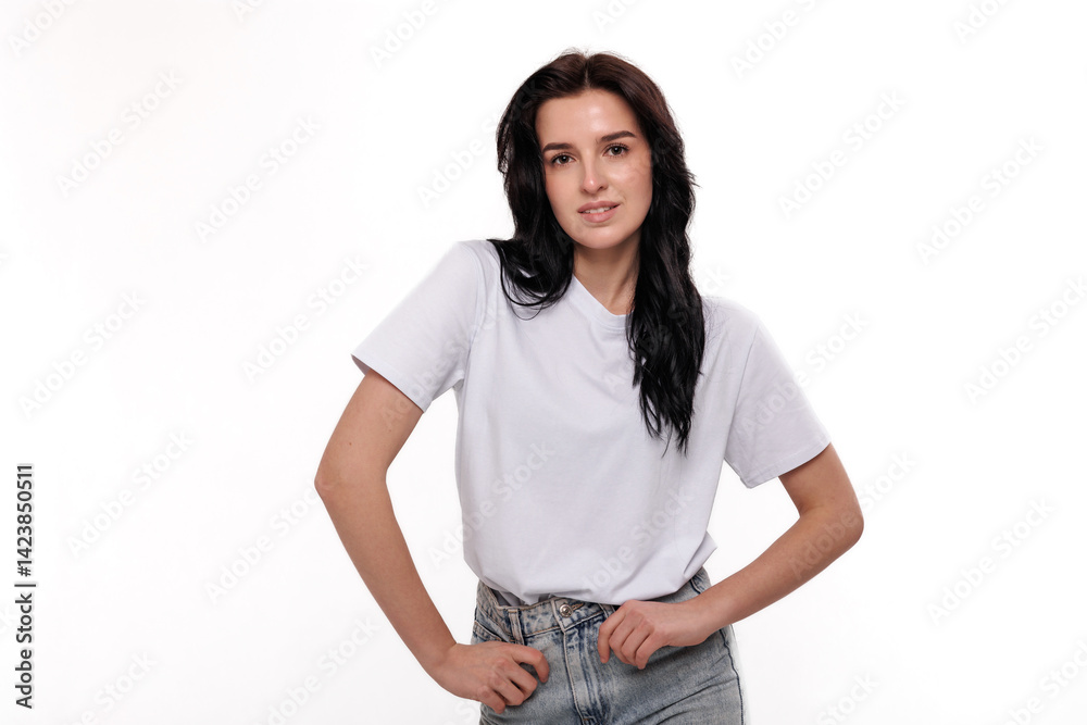 Fototapeta premium Young woman posing confidently in casual attire against a plain background during a photoshoot