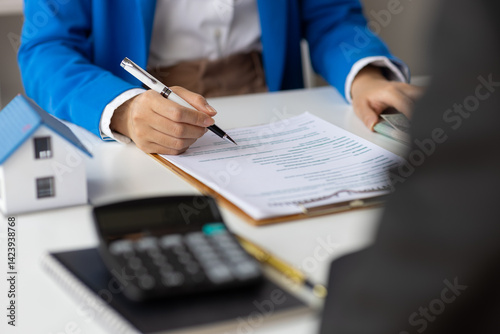 Real estate agents negotiate for businessman to legally sign home purchase agreements contract , rent, mortgage, lease. Businesswoman signs house purchase contract.
