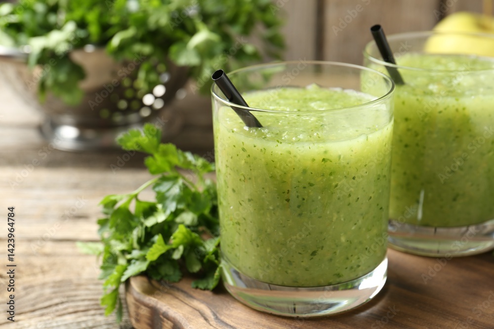 Healthy parsley smoothie in glasses and leaves on wooden table, closeup Healthy parsley smoothie in glasses and leaves on wooden table, closeup