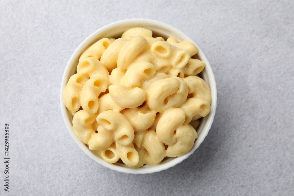 Delicious pasta with cheese sauce in bowl on grey table, top view Delicious pasta with cheese sauce in bowl on grey table, top view