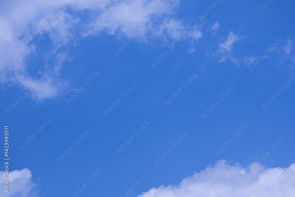 Obraz premium Fluffy Clouds Against a Vibrant Blue Sky