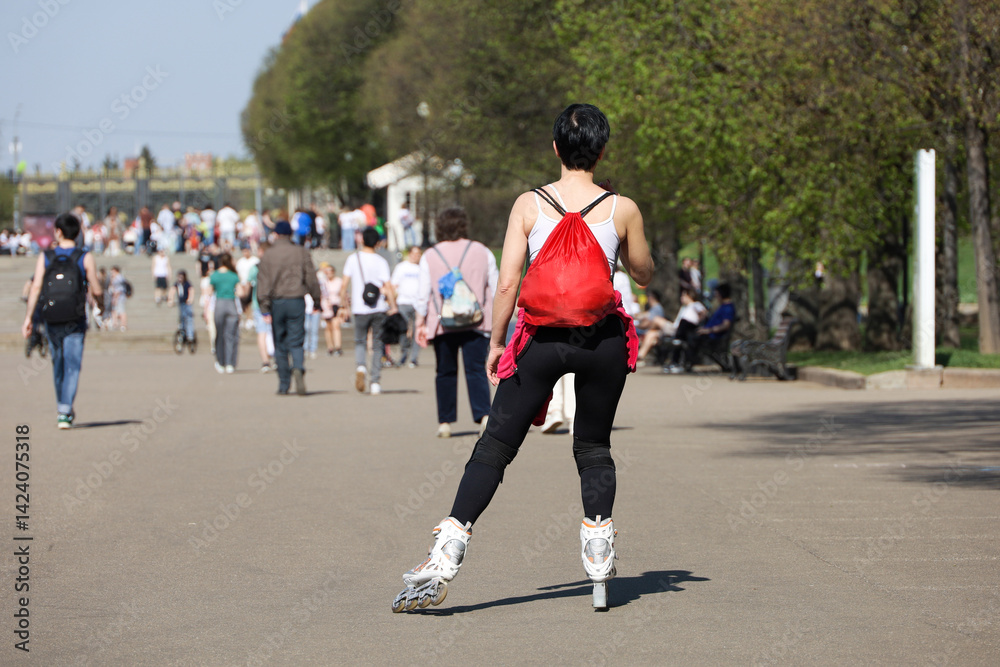 Roller skating, girl riding on rollers on a street on people background. Concept of sport, healthy lifestyle in city